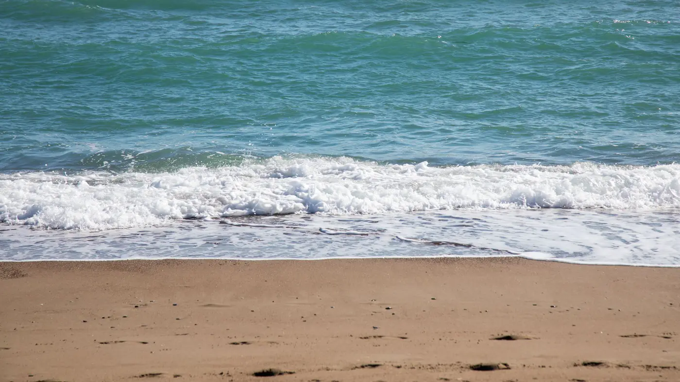 Peaceful beach scene in Turkey with calming waves and golden sand.