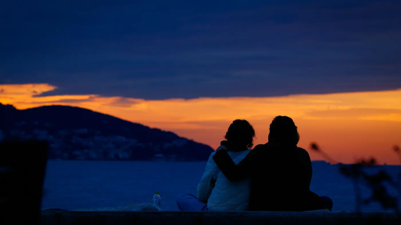 Couple enjoying a beautiful sunset over the sea in Istanbul. Perfect for travel and romance themes.