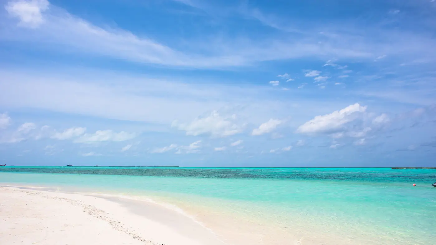Pristine tropical beach with turquoise water and a clear blue sky, ideal for travel inspiration.